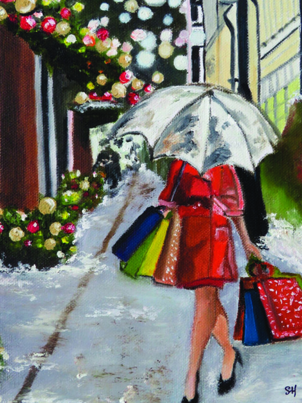 A woman in a red coat carries colorful shopping bags under an umbrella, walking along a festive, decorated street