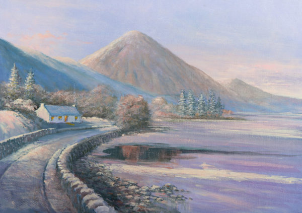Snow-covered landscape with Croagh Patrick mountain, a winding road, and a quaint cottage by a serene lake