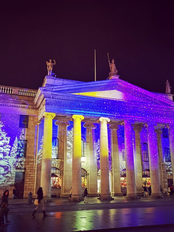 Illuminated GPO building in Dublin, adorned with colorful lights and Christmas tree projections at night