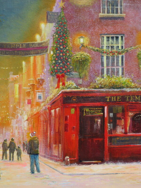 Snowy street scene in Temple Bar, Dublin, featuring a festive pub adorned with Christmas decorations and lights