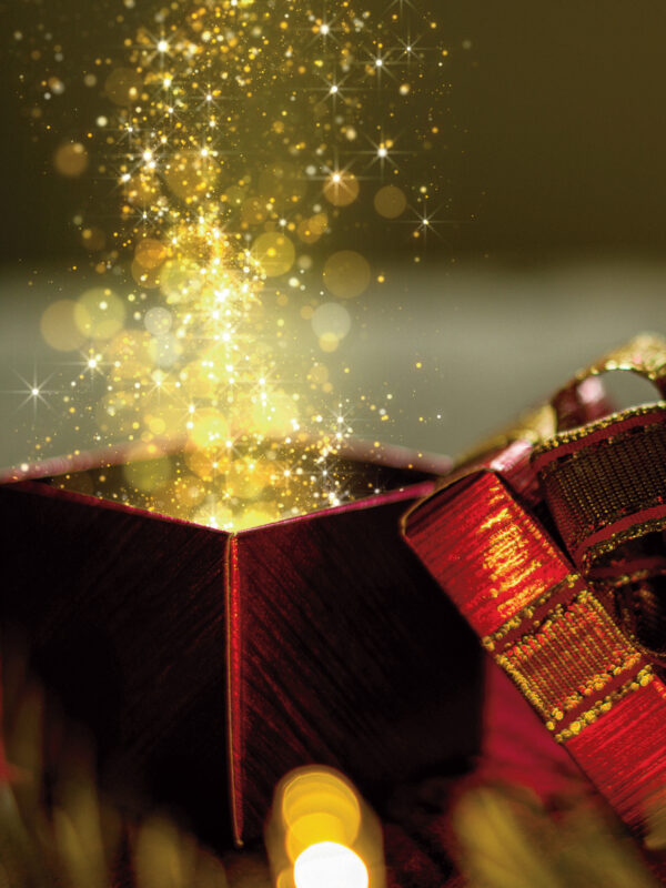 A red gift box with a shimmering golden glow and sparkles emerging from it, surrounded by festive decorations